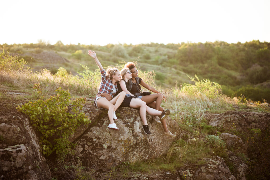 girls smiling, sitting on rock, enjoying view in canyon. girls smiling, sitting on rock, enjoying view in canyon.